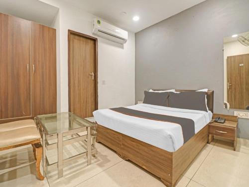 新德里HOTEL Seven Heaven -Lawrence Road New Delhi的一间卧室配有一张床和一张玻璃桌