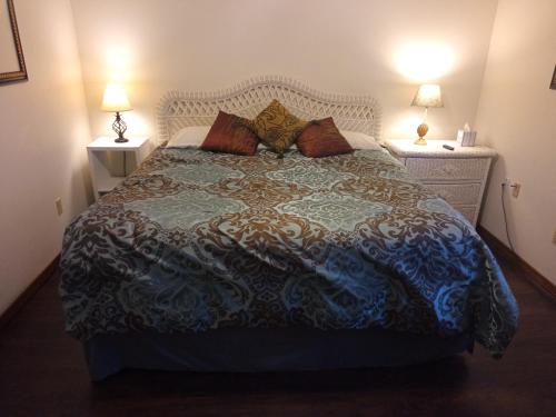 长滩Oakhaven Annex的一间卧室配有一张大床和两盏灯