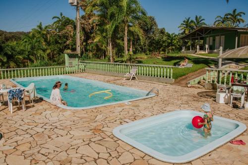 安东尼娜Suítes Romanetto com Piscina e Vista - Antonina的游泳池有2名儿童玩耍