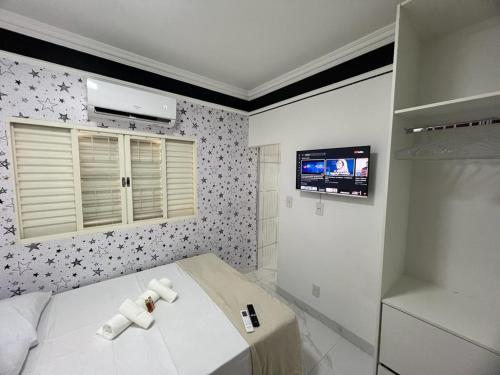乌贝兰迪亚Pousada automática sem recepção 2的卧室配有一张床,墙上配有电视。