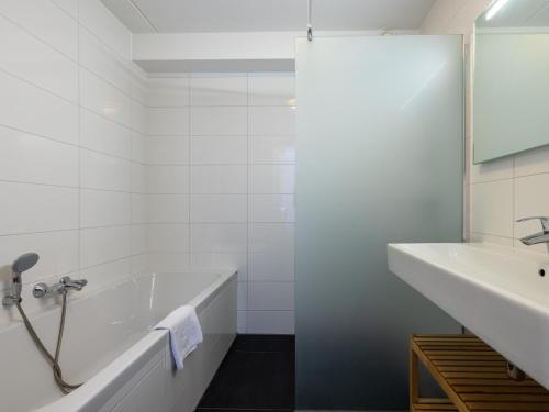 厄伊特海斯特Assum Great的白色的浴室设有浴缸和水槽。