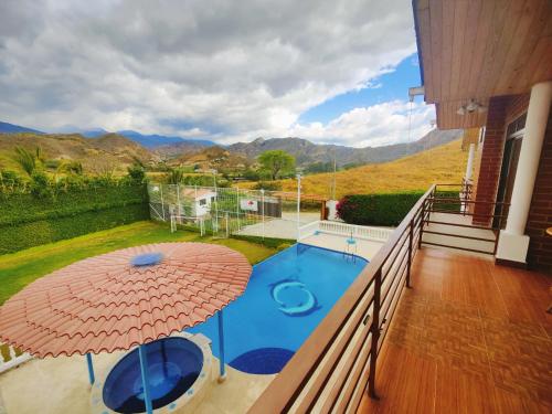 洛哈Quinta Esperanza的阳台配有遮阳伞和游泳池。