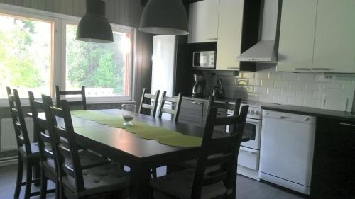 BillnäsMetsäniityn Tuvat的厨房配有木桌、椅子、桌子和窗户。