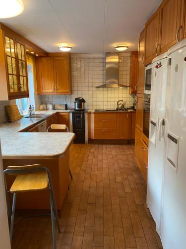 泰比Stockholm-Arlanda privat rum i rymlig villa gratis wifi 1Gb fiber parkering Room1的厨房配有木制橱柜和白色冰箱。