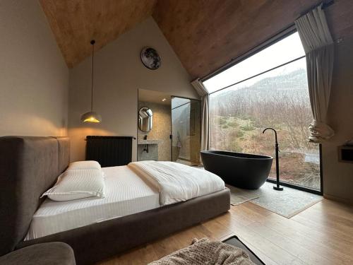 BogëNorth Alpine Villas的一间带大窗户和浴缸的卧室