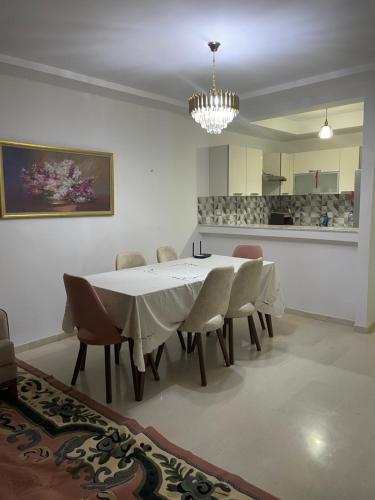 ManūbahMolk的一间配备有白色桌椅的用餐室