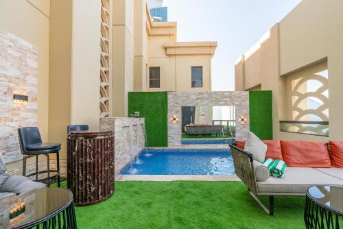 迪拜ELAN RIMAL SADAF Suites的后院设有游泳池和绿草