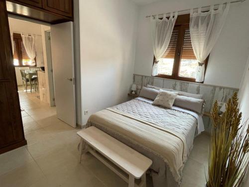 Muelas del PanKruna的一间卧室配有一张带窗户和长凳的床