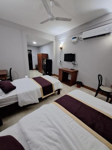 艾藻尔Hotel Chhungte International的酒店客房设有两张床和电视。