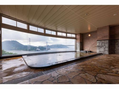 下关Kaikyo View SHIMONOSEKI - Vacation STAY 15380v的大型客房设有大窗户和大型游泳池。