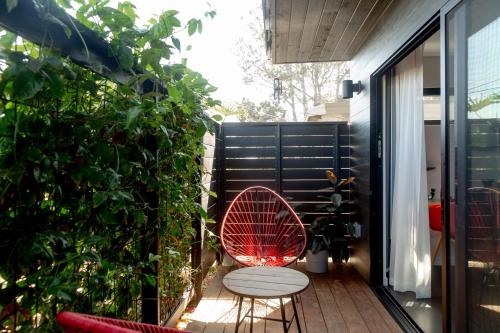 恩西尼塔斯Twelve Senses Retreat, a Member of Design Hotels的天井上配有红色椅子的小阳台
