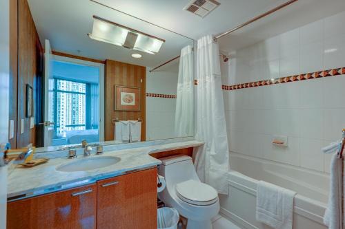 温哥华杜诺文酒店的一间带卫生间、水槽和镜子的浴室