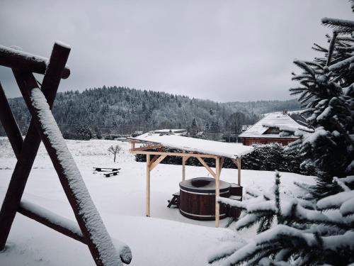 巴利格鲁德Domek na Słonecznym Pagórku的雪覆盖的院子中的木制凉亭