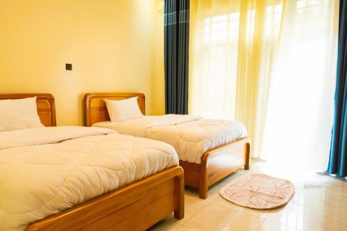 Mgahinga residence的一间卧室设有两张床和窗户。
