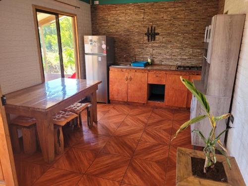 安加罗阿Cabaña tongarikii的厨房配有木桌和冰箱。