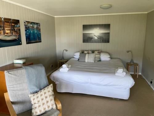 拉塞尔The Pacific Room, Tapeka Point的一间卧室配有一张大床和一把椅子