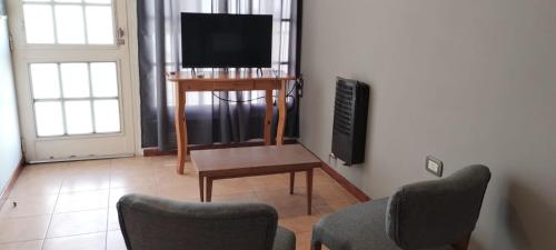 里奥夸尔托Departamento Amoblado Rio Cuarto 2的客厅配有电视和桌椅