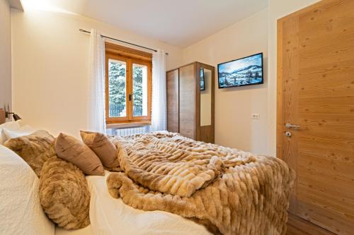 利维尼奥Dany Lodge Livigno的一间卧室设有一张大床和一个窗户。