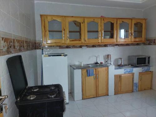 Sere KundaSuleimane guest的厨房配有木制橱柜和白色冰箱。