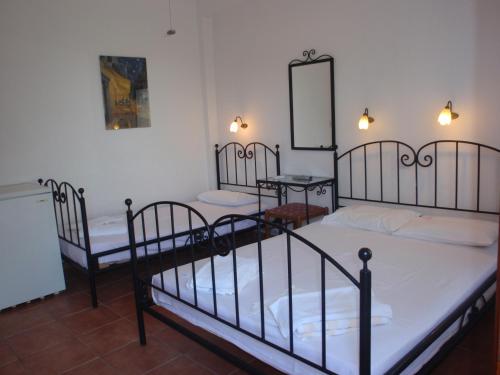 萨莫色雷斯佩特卢达之家旅馆的带三张床和镜子的客房