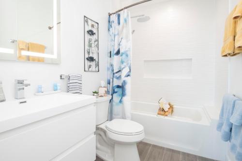 Red Bay EstateAllure #22 3BR Waterfront的白色的浴室设有卫生间、水槽和浴缸。