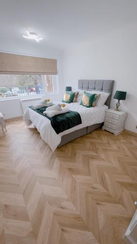 伯恩茅斯Luxury apartment in Bournemouth的一间卧室设有一张大床,铺有木地板