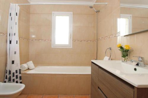阿尔库迪亚Villa Amoros的带浴缸和盥洗盆的浴室