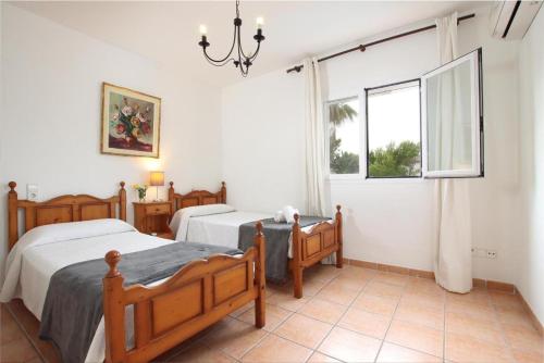 阿尔库迪亚Villa Amoros的一间卧室设有两张床和窗户。