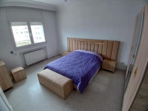 艾尔亚奈calm inn Centre Urbain Nord的一间卧室配有一张床和一把椅子,还有两个窗户