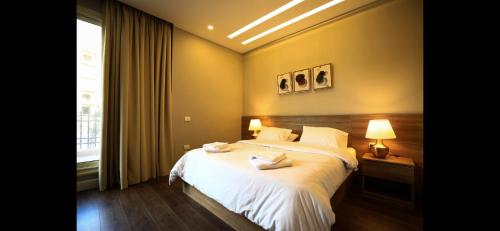 开罗Maison 7 New Cairo的一间卧室设有一张大床和一个窗户。