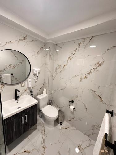 萨拉热窝Royal Moon Suites的一间带卫生间、水槽和镜子的浴室