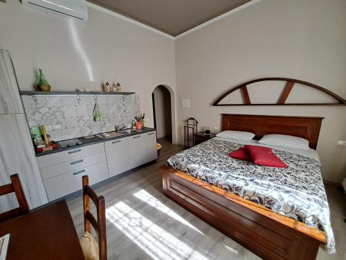 比森齐奥营IL REGNO DI IOSE'的一间卧室配有一张带红色枕头的床