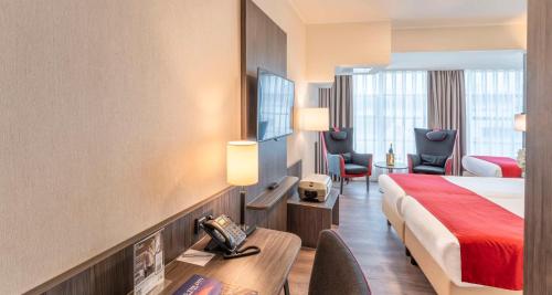 海牙Best Western Plus Plaza Den Haag City Center的酒店客房,配有一张床、一张桌子和椅子