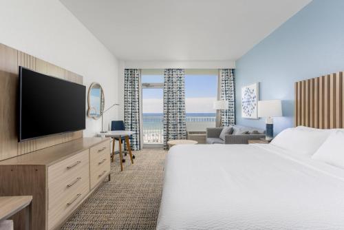 彭萨科拉海滩彭萨科拉海滩度假村的配有一张床和一台平面电视的酒店客房