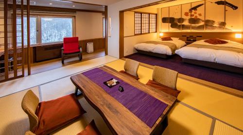 上川町Hotel Taisetsu Onsen&Canyon Resort的一间卧室配有两张床和一张桌子及椅子