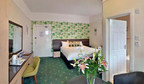 伯恩茅斯Cavendish Central Bournemouth的配有一张床和花瓶的酒店客房
