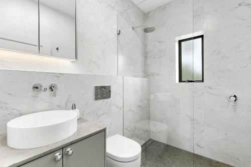 悉尼Hamilton Lodge的白色的浴室设有水槽和卫生间。