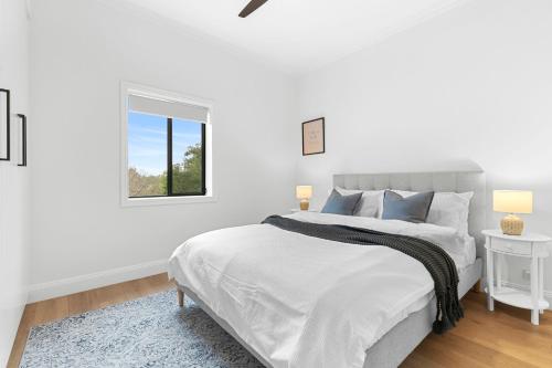 悉尼Hamilton Lodge的白色的卧室设有一张大床和一个窗户