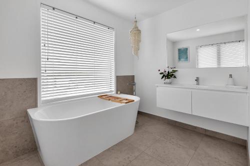 凯塔亚Seaglass - Karikari Peninsula Holiday Home的白色的浴室设有浴缸和水槽。