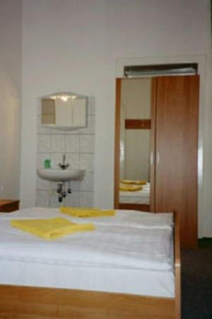 柏林佩西恩婚礼酒店的一间卧室配有一张带水槽和镜子的床