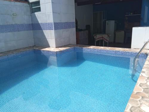 蒙加瓜Casa de Praia com Piscina em Mongagua - Disponivel Carnaval的一座蓝色瓷砖的大型游泳池