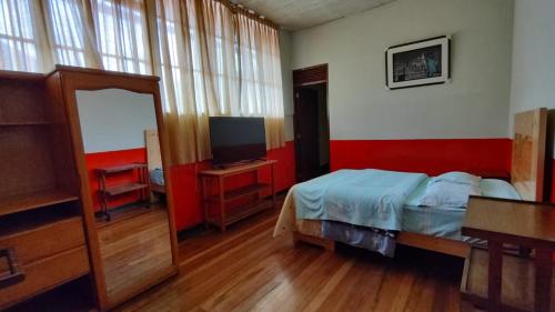 塔尔马Hospedaje Colonial Tarmeño.的一间卧室配有一张床和电视