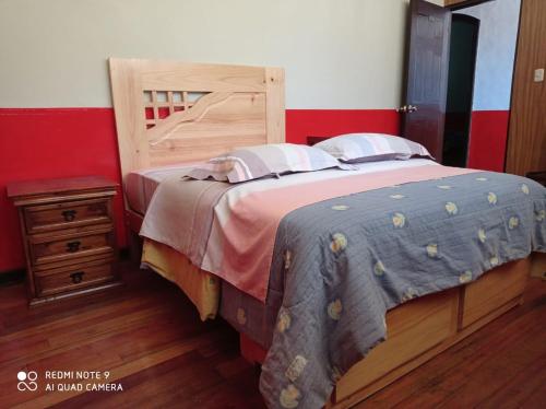 塔尔马Hospedaje Colonial Tarmeño.的一间卧室配有一张大床和木制床头板