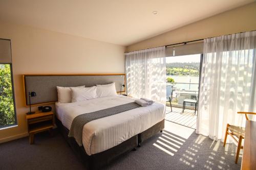 罗斯福尔斯Rosevears Riverview Hotel的一间带大床的卧室和一个阳台