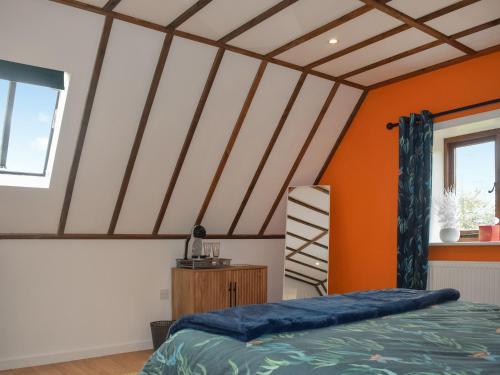 AshburnhamKingfisher Granary的一间拥有橙色和白色天花板的卧室