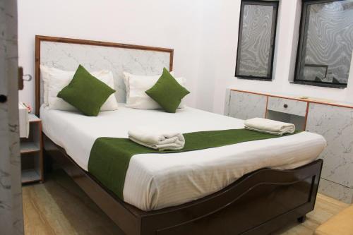 卡兰古特VILLA CASA SUMANJO (3BHK)的一间卧室配有一张带绿色和白色枕头的大床