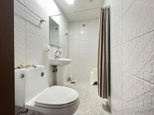 Katakaiゴールデンビーチホテル的白色的浴室设有卫生间和水槽。
