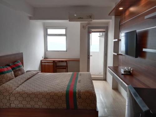 ParungdengdekSansan Room - Apartemen Gunung Putri Square的一间卧室配有一张床和一台平面电视