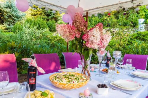 JasienicaVilla Agnes Jacuzzi & Sauna的一张带粉红色花的桌子和披萨