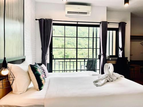 卡马拉海滩PP GRAND KAMALA HOTEL-SHA Extra Plus的卧室配有白色的床和大窗户